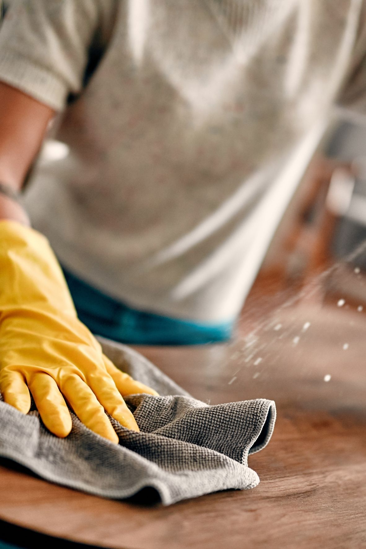 Main gantée essuyant un miroir rond dans une salle de bain lumineuse et épurée à Delson