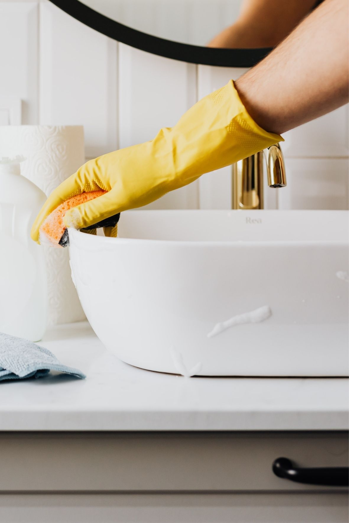 Main gantée nettoyant un lavabo dans un espace sanitaire moderne et propre  à Lorraine