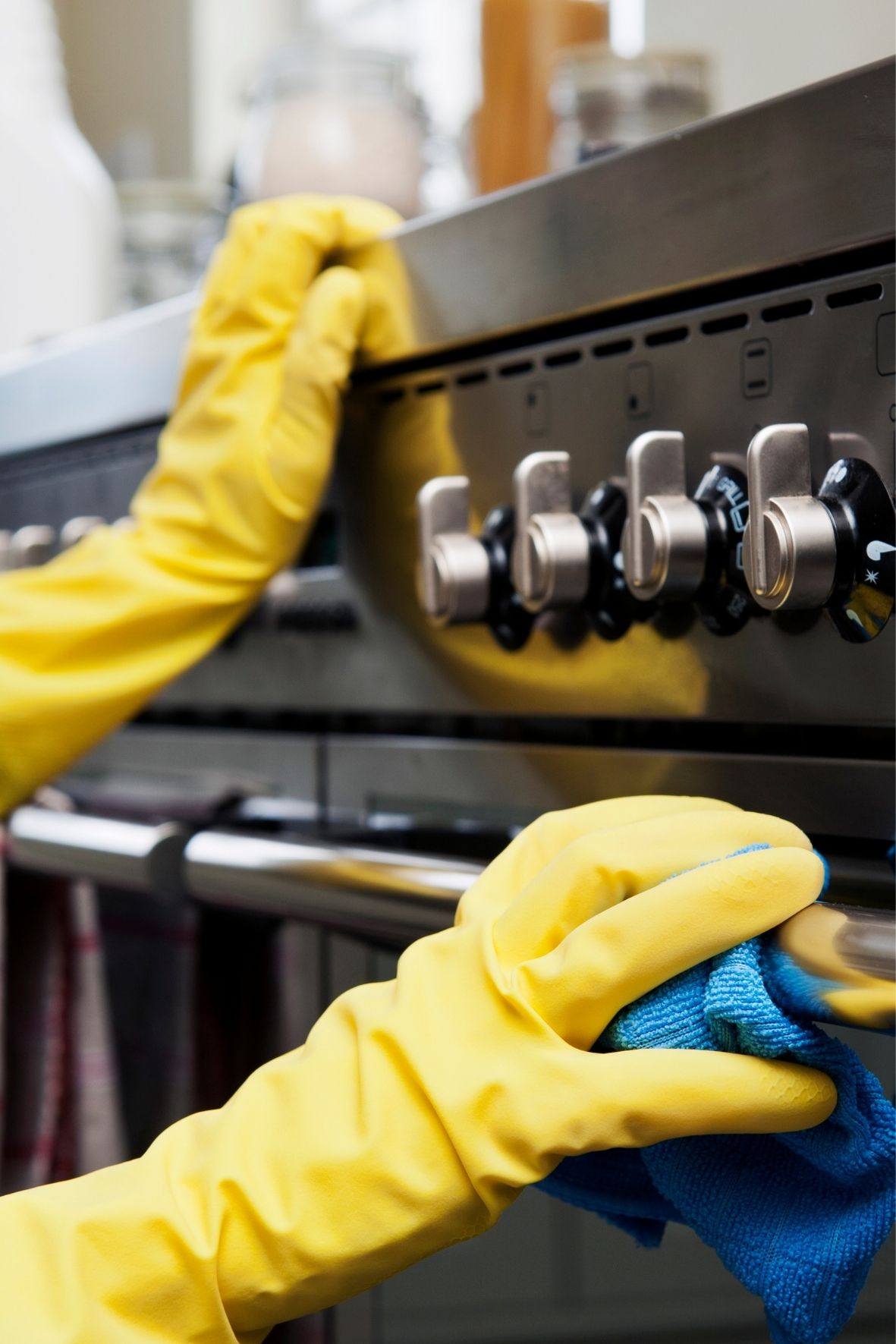 Main gantée nettoyant une surface d’électroménager dans un cadre domestique soigné  à Saint-Colomban